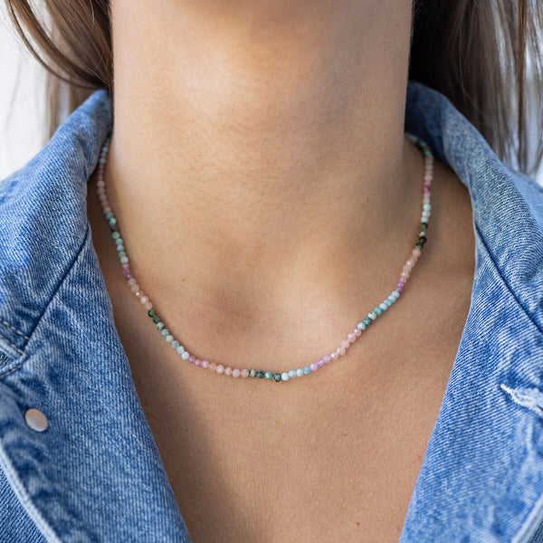 Model wearing dainty pink and blue beaded necklace