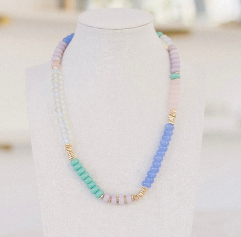 Beaded necklaces in clear, green, blue and pink beads with accenting gold beads.