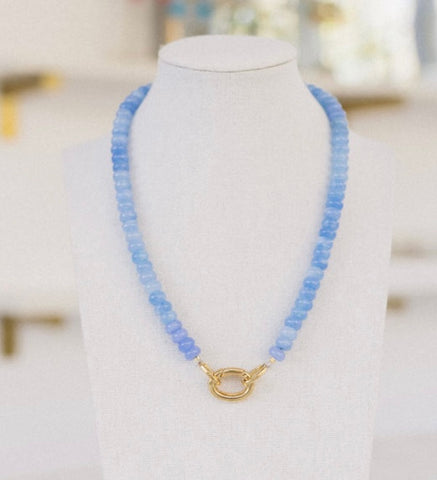 Bright light blue beaded necklace with a gold clasp.