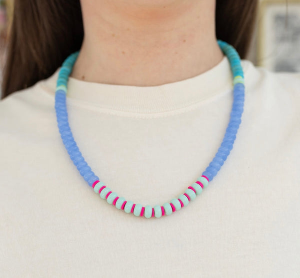 Picture of model wearing a beaded blue, turquoise, pink and light blue necklace.