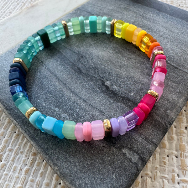 Picture of a multicolored rectangular beaded bracelet in clear and solid colors. Colors are greens, blues, pinks, purples and yellows.