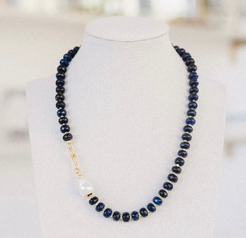 Picture of navy colored beaded necklace with a Carabiner clasp and a fresh water pearl.