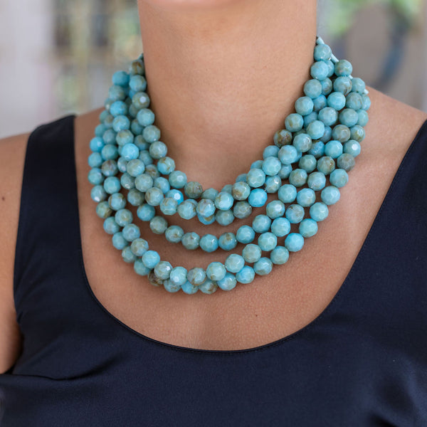 Woman wearing a resin blue beaded layered necklace