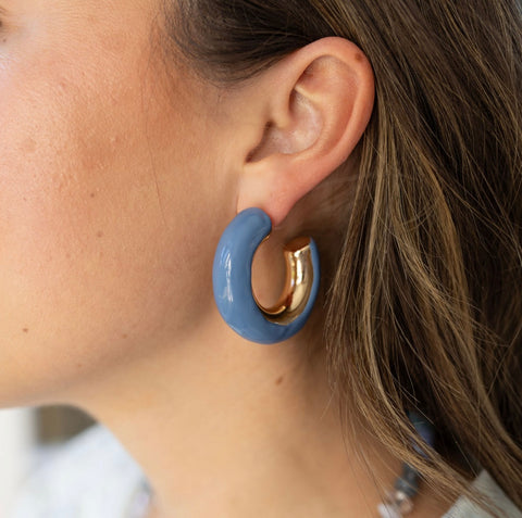 Model wearing chunk gold hoop earring with blue accent