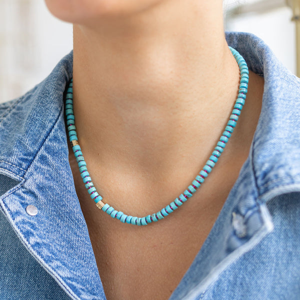 Woman wearing a blue/green beaded short necklace/choker around her neck