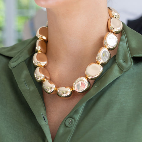 Woman wearing a chunky gold bead necklace