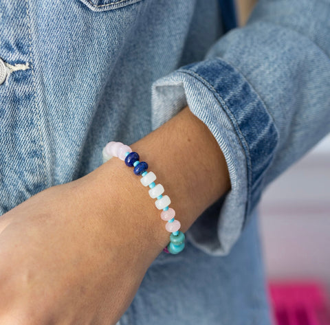 Picture of model's wrist wearing a white and blue beaded bracelet.