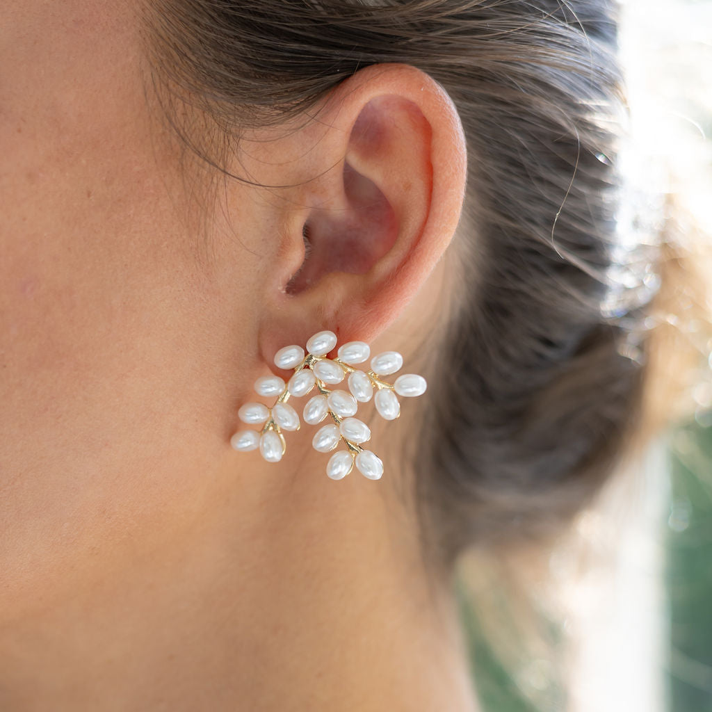 Woman wearing gold and peal earring studs 