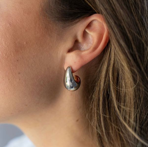 Model wearing chunky silver crescent earring