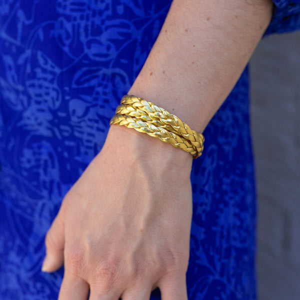 Woman wearing a gold braided double layered bracelet on her wrist