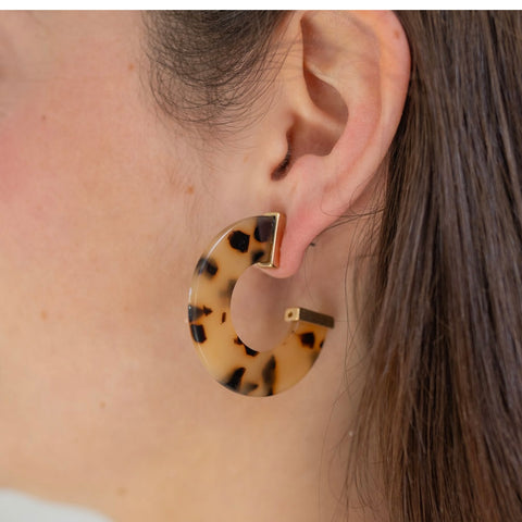 Picture of model wearing a chunky cheetah print resin hoops with gold accents.