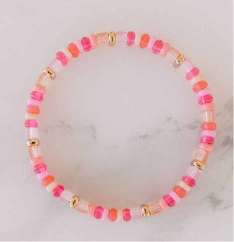 Picture of a single beaded bracelet in alternating colors of pink, coral, gold and white