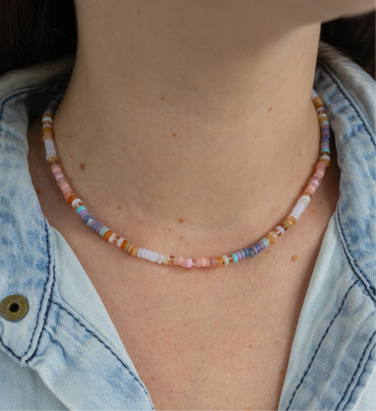 Woman wearing rainbow colored beaded short necklace around her neck