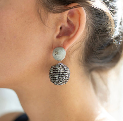 Woman wearing a gray beaded thread stud and beaded circle drop bauble earring