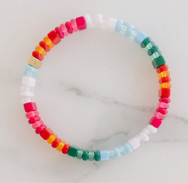 Picture of a single beaded bracelet in reds, oranges, pinks, whites and blues.