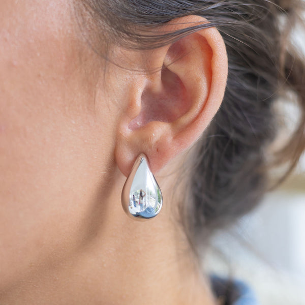 Woman wearing silver teardrop earrings 