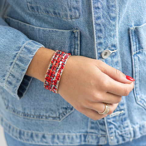 Woman wearing an orange/cream knitted cloth bracelet on her wrist