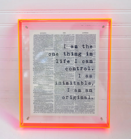 Decor with a bright orange clear frame with a book page inside with a quote