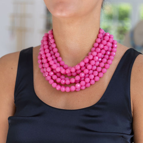 Woman wearing a resin hot pink beaded layered necklace