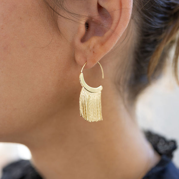 Model wearing gold fringe hoop earring