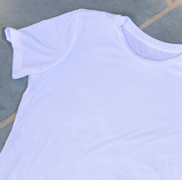 A plain short-sleeve white t-shirt on the floor 