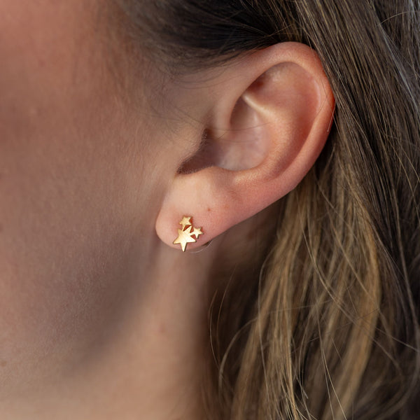 Petite three star gold stud earring on model