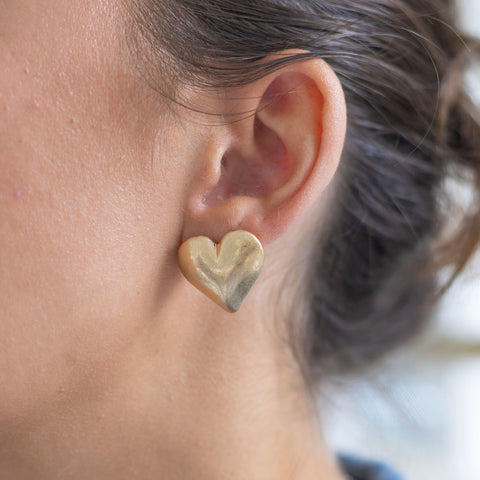 Woman wearing a gold heart stud earring