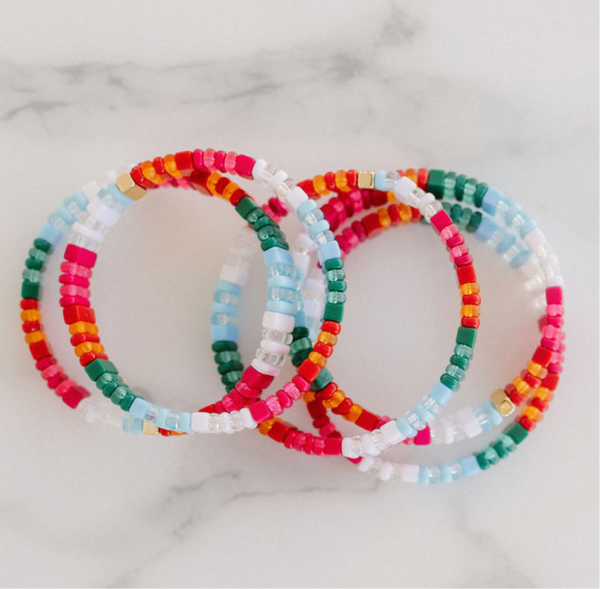 Set of 5 bracelets with various hues of pinks, reds and oranges, also white, blue and greens.