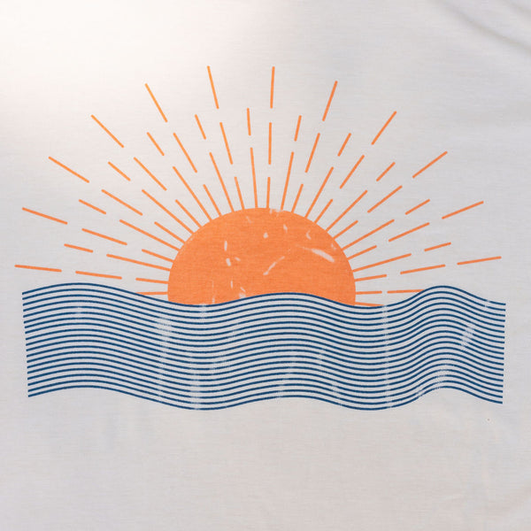 A plain white shirt with an image of an orange sun rising over an ocean 